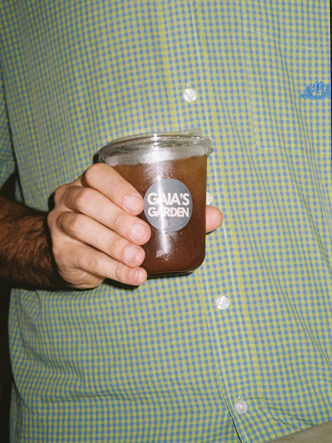 Un café con hielo de Gaia's Garden en la mano